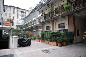 einen Innenhof eines Gebäudes mit Topfpflanzen in der Unterkunft Trilocale zona Farini/Isola in Mailand