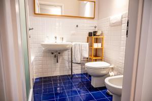 La salle de bains blanche est pourvue d'un lavabo et de toilettes. dans l'établissement Trilocale zona Farini/Isola, à Milan