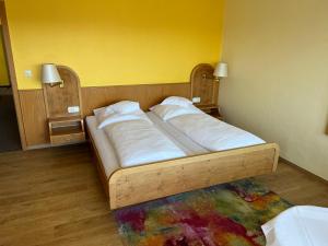 a bedroom with a bed with white pillows on it at Hotel Schwan in Hügelsheim