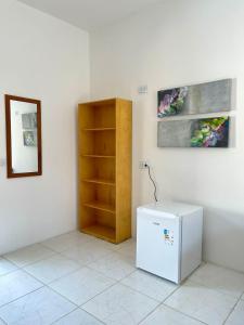 a room with a white refrigerator and a shelf at Hostel Jeri Central in Jericoacoara