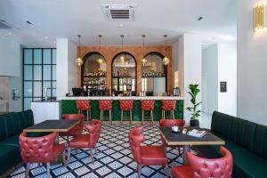 un ristorante con sedie e tavoli rossi e un bar di Naillac Boutique Hotel a Città di Rodi