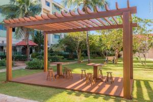 uma pérgola de madeira com mesas e cadeiras num parque em Hotel Vale Verde em Campo Grande