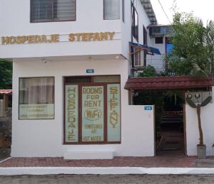 a white building with a sign on the door at Stefany Hospedaje in Puerto Ayora
