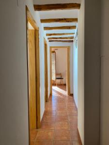 a hallway with white walls and wooden ceilings at Dúplex Teresa in Alcañiz