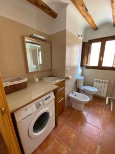 a bathroom with a washing machine and a toilet at Dúplex Teresa in Alcañiz +11 photos