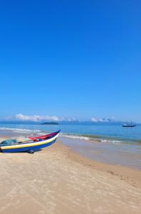 um barco sentado na areia numa praia em Pousada do Sol em Florianópolis