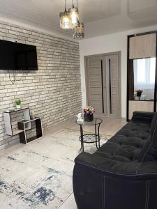 ein Wohnzimmer mit einem Sofa und einem Tisch in der Unterkunft 1комн квартира в Башне Близнецах in Oral
