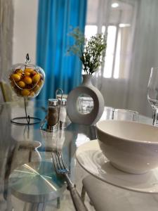 einen Glastisch mit einer Schüssel Orangen und einer Vase in der Unterkunft 1комн квартира в Башне Близнецах in Oral