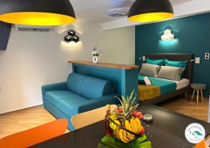 a living room with a blue couch and a bed at Studio situé à 30 mètres de la plage Anse à l'âne in Les Trois-Îlets
