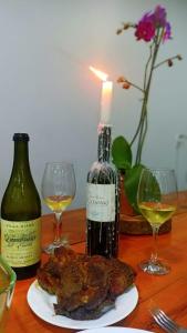uma mesa com duas garrafas e dois copos de vinho em Recanto Felicitá em Foz do Iguaçu