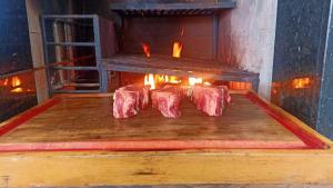Se están cocinando cuatro piezas de carne en un horno. en Recanto Felicitá, en Foz do Iguaçu
