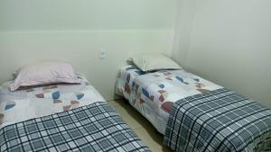 dos camas sentadas una al lado de la otra en una habitación en Recanto Felicitá, en Foz do Iguaçu
