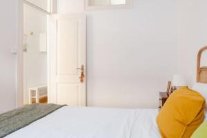 a bedroom with a white bed and a white door at Bright cozy flat by river in an quiet art zone in Lisbon in Lisbon