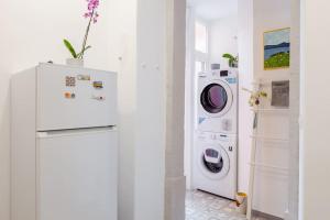 a white laundry room with a washer and dryer at Bright cozy flat by river in an quiet art zone in Lisbon in Lisbon