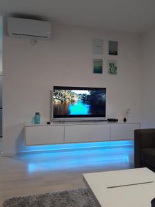 a living room with a television with blue lights at Elena apartmani Tuzla in Tuzla +2 photos