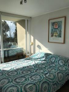 Schlafzimmer mit einem Bett und einem Fenster in der Unterkunft Hermoso Departamento a 5 min. caminando a la playa in Papudo