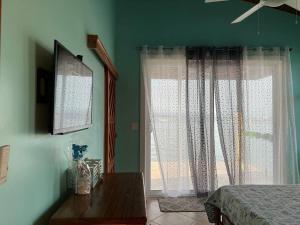 a bedroom with green walls and a bed and a window at Casita Azul in Bastimentos