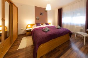 a bedroom with a large bed with purple blankets at Apartment Nina-bazen-klima-parking in Otočac