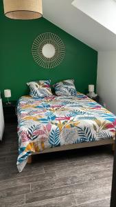 - une chambre dotée d'un lit avec un mur vert dans l'établissement Charmante maison à deux pas de la mer, à Gouville-sur-Mer