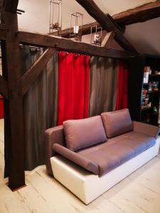 eine Couch vor einem roten Vorhang in der Unterkunft Maison familiale de l Abbaye in Clairvaux