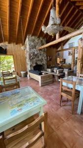 a living room with a table and a stone fireplace at Hostería Brisas del Cerro in Villa La Angostura