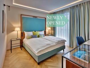 1 dormitorio con 1 cama con un cartel de apertura reciente en EST Grand Hotel Savoy en Budapest
