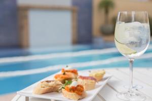 a plate of food next to a glass of wine at Vila Olimpia Hotel in Sao Paulo