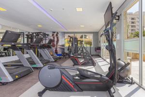 a gym with several treadmills and elliptical machines at Vila Olimpia Hotel in Sao Paulo