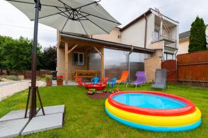 a backyard with an inflatable pool and an umbrella at Apartmány Alice in Veľký Meder