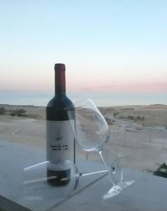 a bottle of wine sitting on top of a window at family apartment Dead-sea view in Ovnat