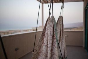 two bags hanging in a room with a window at family apartment Dead-sea view in Ovnat