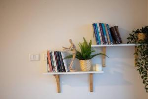 a shelf with a doll sitting on top of books at family apartment Dead-sea view in Ovnat
