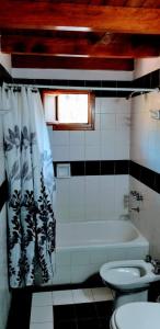 y baño con bañera, aseo y lavamanos. en Cabaña Camalen en San Martín de los Andes