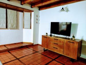 una sala de estar con TV de pantalla plana en una cómoda de madera en Cabaña Camalen en San Martín de los Andes