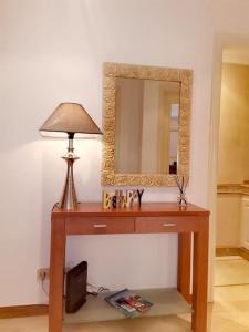 a dressing table with a lamp and a mirror at Enjoy Beloura! in Sintra