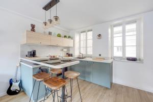 a kitchen with a blue island and stools at A place to chill in Paris