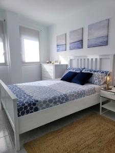 1 dormitorio con 1 cama grande con almohadas azules en ALLINSEA LA GARITA en La Garita