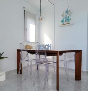 una mesa de comedor con sillas blancas alrededor en ALLINSEA LA GARITA, en La Garita