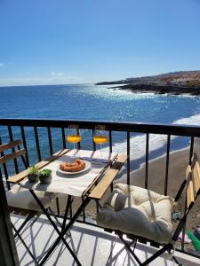 een tafel en stoelen op een balkon met uitzicht op het strand bij ALLINSEA LA GARITA in La Garita