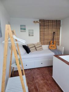a bedroom with a white bed with a guitar at ALLINSEA LA GARITA in La Garita