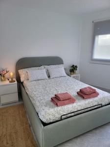 uma cama com duas almofadas num quarto em ALLINSEA LA GARITA em La Garita