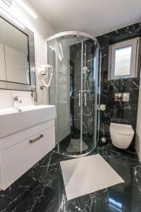 czarno-biała łazienka z prysznicem i umywalką w obiekcie Apartament Wilaneska w mieście Krynica Zdrój