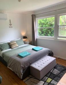 a bedroom with a large bed and a window at Relaxing cottage overlooking Crookhaven River in Greenwell Point