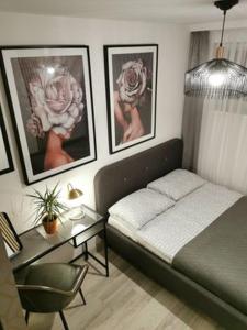sypialnia z łóżkiem, stołem i zdjęciami w obiekcie Apartament w Choczewie w mieście Choczewo