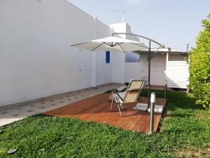 a patio with a chair and an umbrella at Le Stelle di Orione in Fontane Bianche