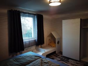 Schlafzimmer mit einem Bett und einem Fenster in der Unterkunft Modernes behagliches Haus mit Kamin, Terrasse und Garten in Magdeburg