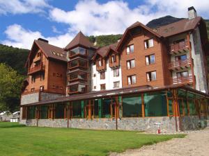 a large building in front of a green field at Hotel Natura in Peulla