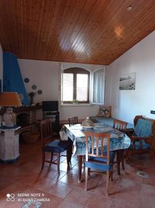 uma sala de jantar com uma mesa e algumas cadeiras em Villa Mediterraneo em Castelluzzo