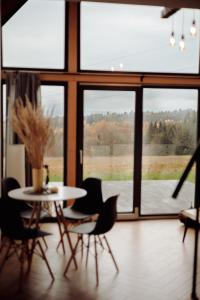 a dining room with a table and chairs and windows at Osada Przejrzysko in Jordanów