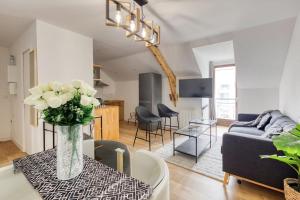 a living room with a vase of flowers on a table at Le cosy in Saint-Cyr-lʼÉcole